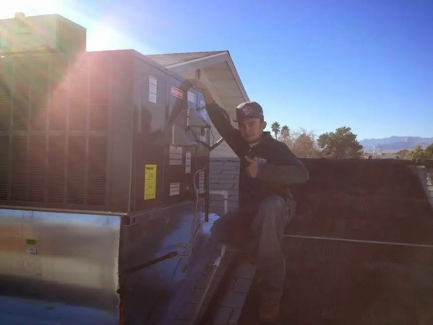 HVAC technician performing Heat Pump Repair on a rooftop unit in Bristol